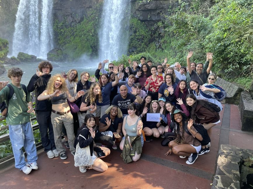 High school students posing in front of a waterfall in Argentina