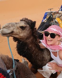 Student in the desert of Morocco posing with a camel