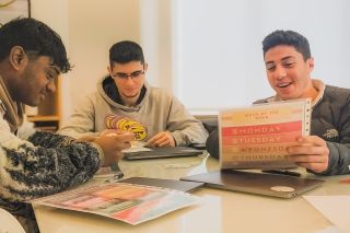 Students looking at worksheet in classroom on program