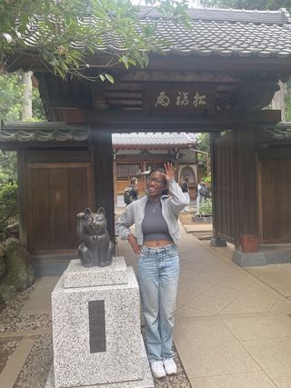 Picture of the author posing with a Maneki-neko statue at Gotokuji 
