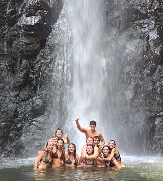 High schoolers posing under waterfall on high school summer program