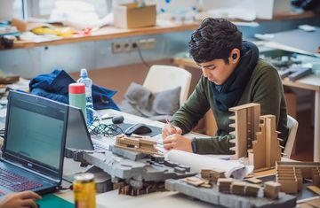 An intern works on a design in a workshop