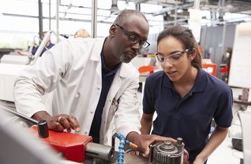 A female intern listens to instructions from her teacher