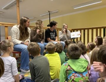 study abroad students read children
