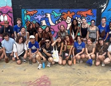 Students with Camil Escruela in front of their mural