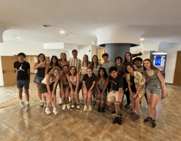 A group of high school students poses for a picture in a hotel lobby