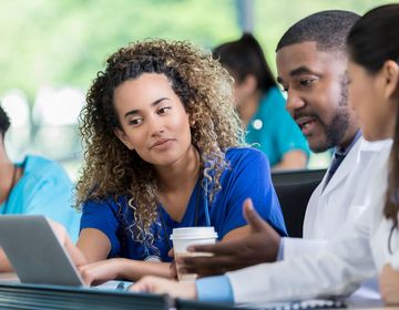 Students sitting in lecture hall looking at laptop