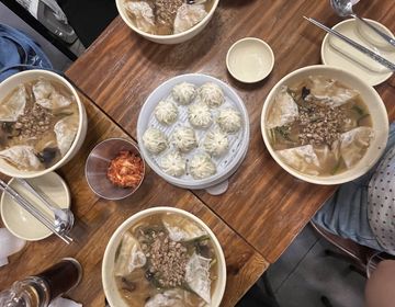 four bowls of noodle soup and dumplings