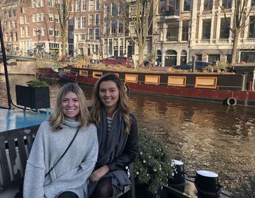 two students sitting by amsterdam canal