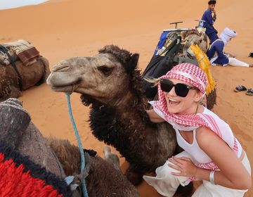 Student in the desert of Morocco posing with a camel