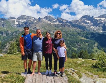 Homestay family with student participant posing in front of scenic mountains