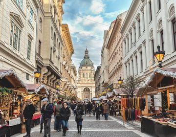 Crowd of people walking on Zrinyi Street during the Christmas holidays in Budapest at dusk.