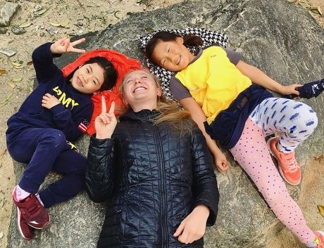 Teacher and students laying on the ground smiling