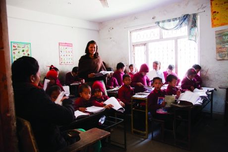 Students sitting at desk while teacher instructs them