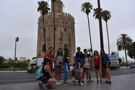 High school students in front of tower and palm trees in Seville