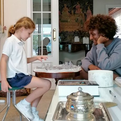 Seville student playing chess with host family's granddaughter