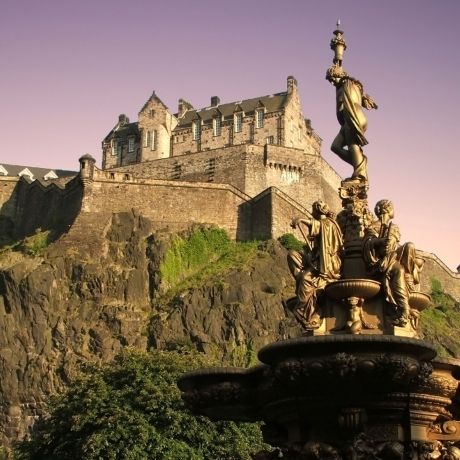 edinburgh castle with statue at sunset