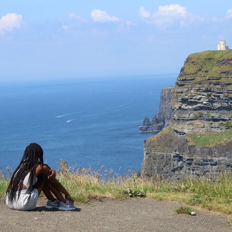 dublin girl overlooking castle on cliffs of moher