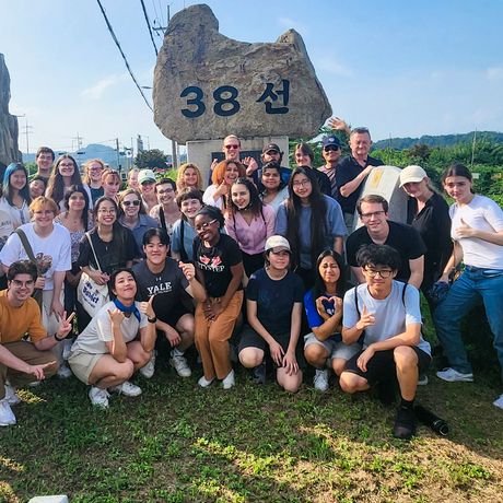 seoul students posing next to the sign for the 38th parallel in the south korean dmz