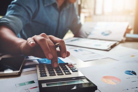 Business man with a calculator looking at financial documents