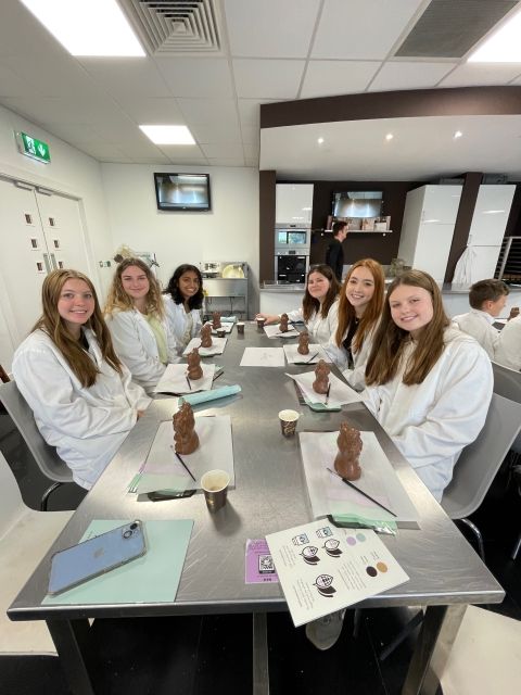 A few GE students decorating their chocolate elephants with melted white chocolate at the Butlers Chocolate Factory.