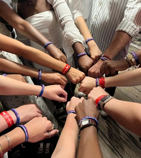 Students Displaying Bracelet in a Huddle