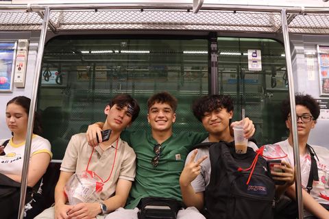 Group of students smiling with their drinks on the metro