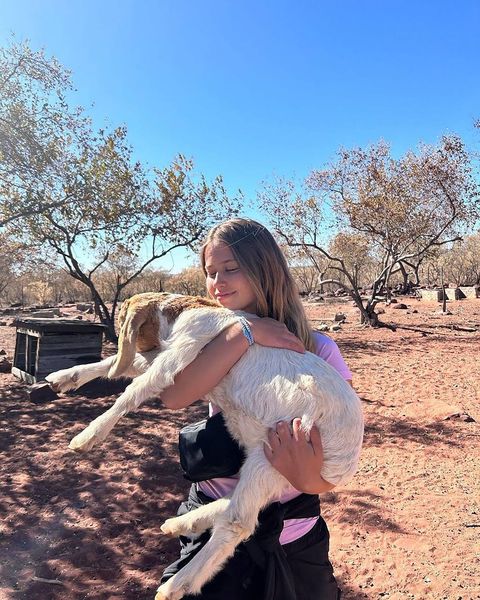 High school student on program holding a goat and smiling