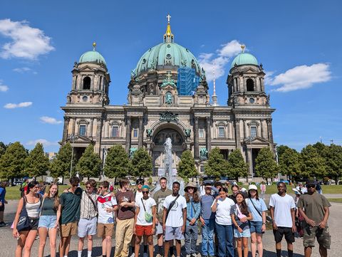 High school students posing in front of a historic building while studying abroad