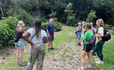 Teacher and students in a huddle outdoors before a study abroad excursion