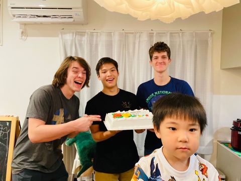 Gap students holding up cake with host family