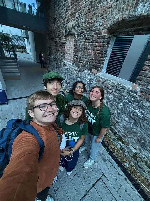 High school student group selfie brick building alley