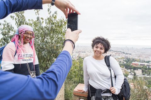 Student participant posing for photo with city skyline behind them