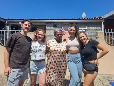 Students in Cape Town posing with their host mother