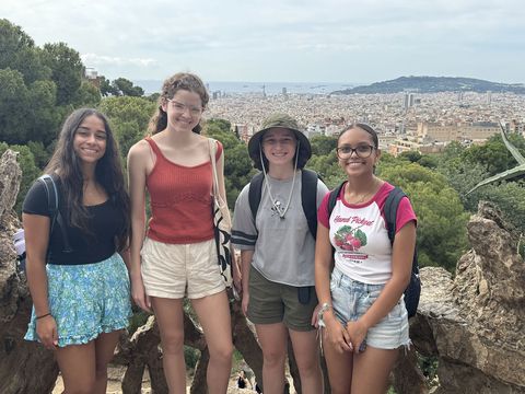 Students posing after hike with city behind them