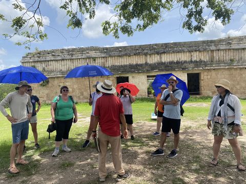 High school teachers outside in Yucatan holding CIEE umbrellas