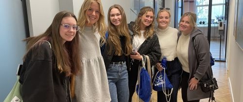 Group of young women in hallway smiling