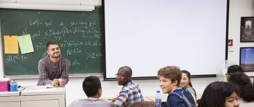 Teacher smiling at full classroom of students in Beijing