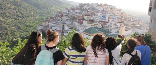 High school students posing above a city in Europe