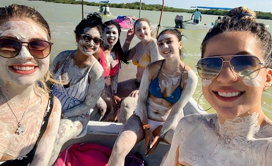 yucatan girls on boat wearing mud