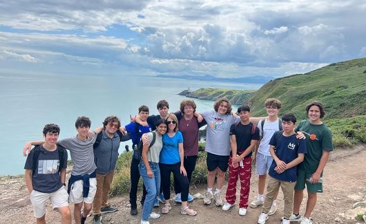 Students standing on mountain facing the sea