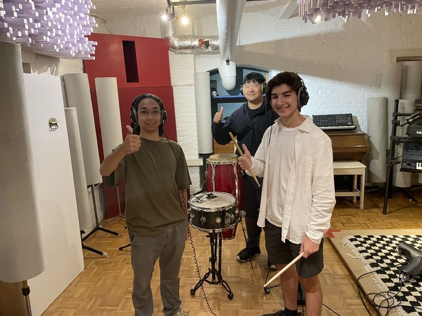 Three male students inside a recording studio