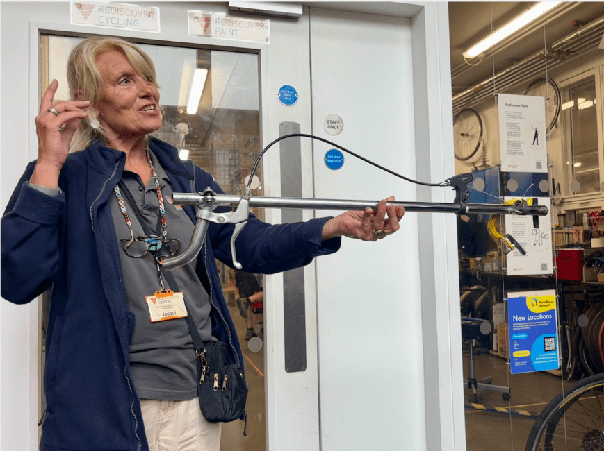 Tour guide, Jackie, displaying a grabber made of our bicycle parts