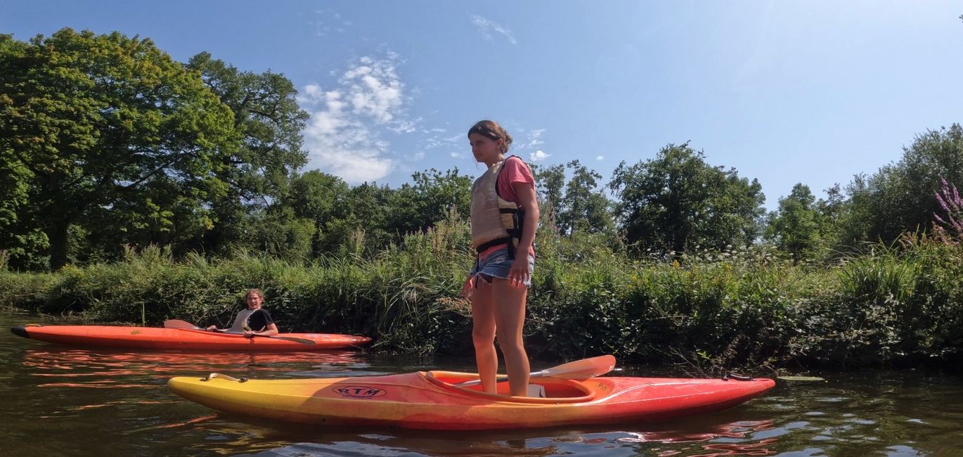 Teen girl standing on her kayak