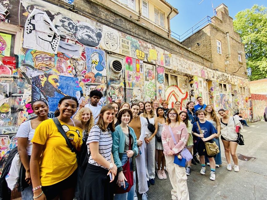 Street Art tour group photo in front of wall covered in art
