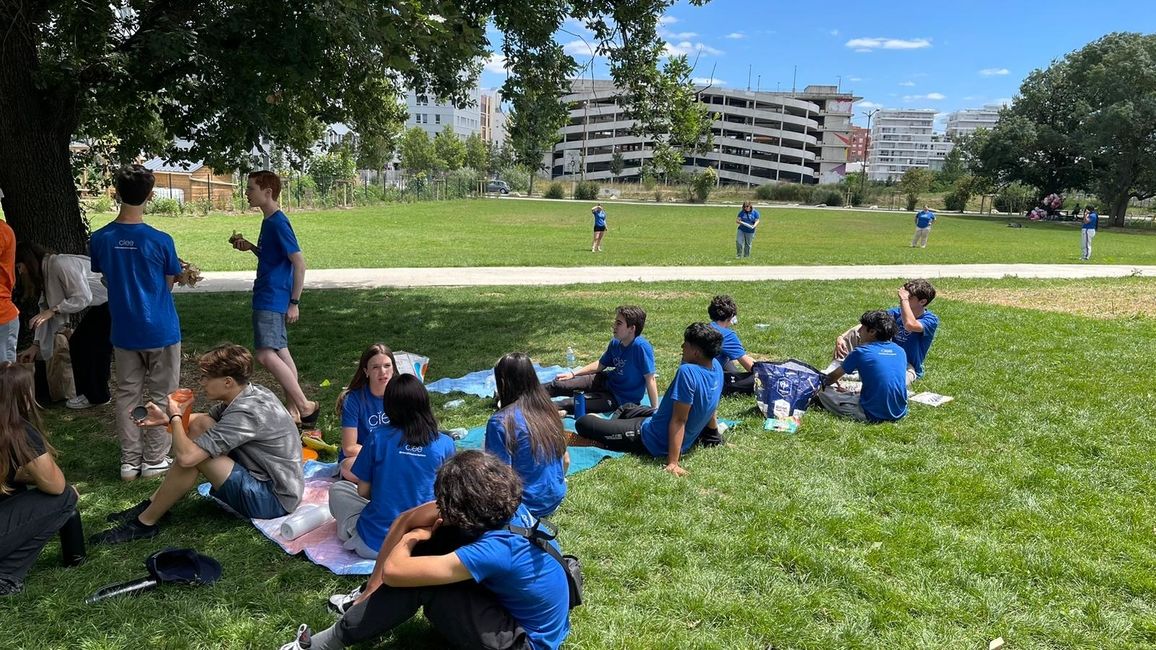 Students in blue t-shirts under a tree