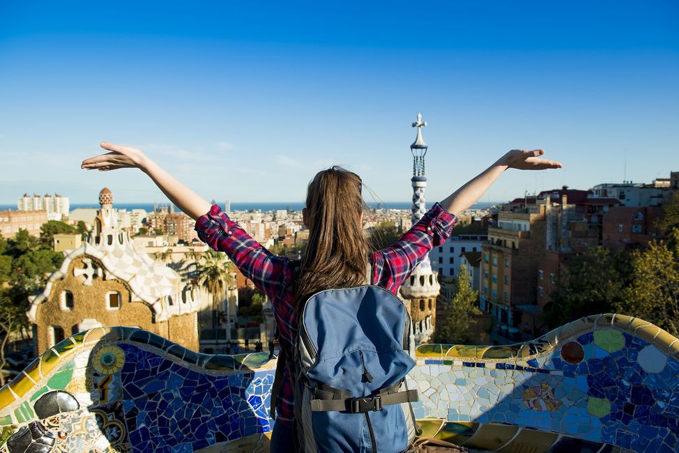 Young female student with arms raised looking at view of Barcelona