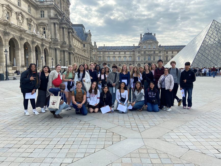 Students posing in front of the Louvre museum in Paris