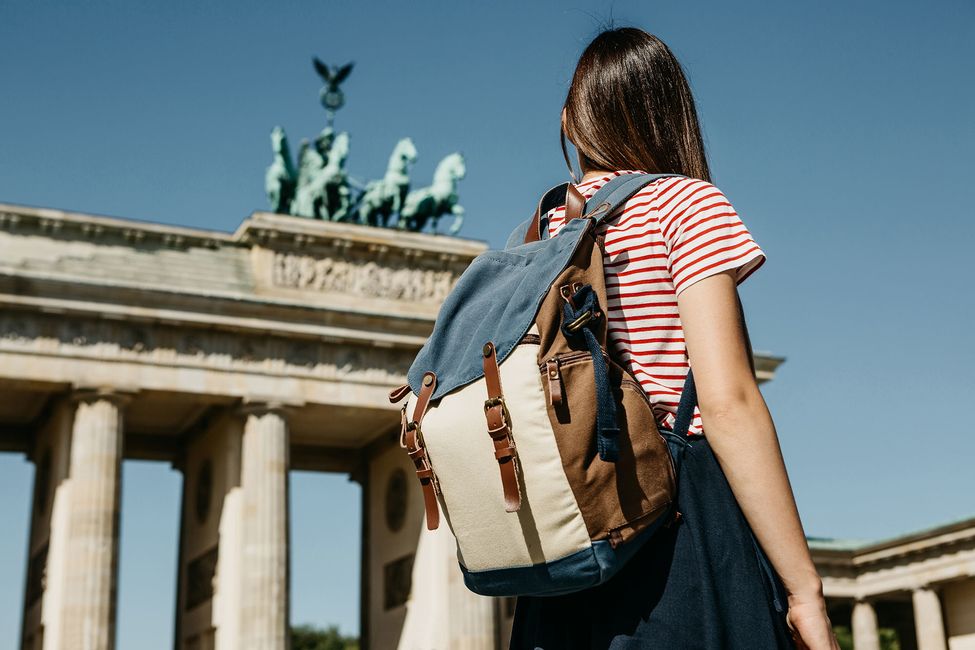 Student with backpack looking at the Brandenburg Gate in Berlin