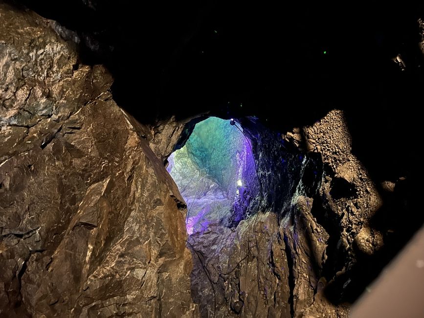 from above, we could see a pool of water a lot deeper down in the cave illuminated by colourful lights!